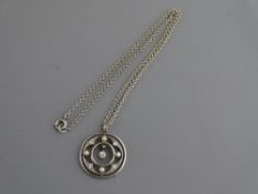 A STERLING SILVER NECK CHAIN with eighteen carat gold circular pearl pendant with tiny drop diamond,