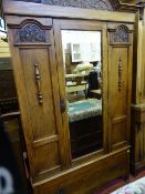 Carved oak single mirrored door wardrobe with lower drawer