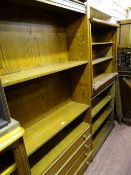 Open oak standing bookcase with four narrow base drawers and three other bookcases (one cream