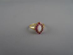 Eighteen carat gold dress ring with oval white opal and twelve surrounding rubies, 3.3 grms, size '