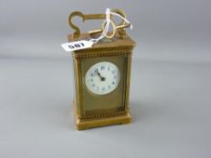 French gilt brass carriage clock, the enamel dial with blue Arabic numerals and satin gilt mask (