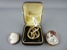 Large Victorian pinchbeck knot brooch and two carved cameo brooches in unmarked yellow metal mounts