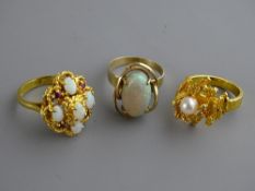Three nine carat gold dress rings to include a single opal, size 'R', an opal and ruby cluster, size