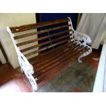 Dark stained wooden slatted bench with ornate metal ends