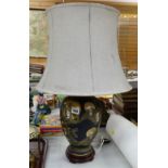 A ceramic gilt & black painted table lamp decorated with Oriental heads