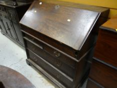 An antique oak drop front bureau with a four-drawer base