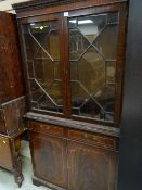 A reproduction mahogany astragal glazed top cupboard bookcase