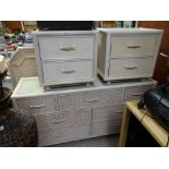 A modern white wicker chest of drawers, two bedside cabinets & a headboard