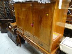 A reproduction inlaid decorated three-door & three-drawer drinks cabinet on carved decorated