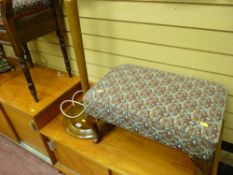 Neatly upholstered footstool and a standard lamp