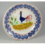 A LLANELLY POTTERY COCKEREL PLATE typically decorated with blue sponged wheel motifs to the