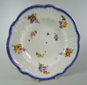 A NANTGARW PORCELAIN SOUP DISH having a lobed border with moulded scrolls, foliage & ribbons,