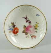 AN UNRECORDED NANTGARW PORCELAIN SAUCER DISH moulded with c-scrolls, flowers and wreaths and