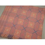 A DERW WELSH BLANKET in pink ground with typical geometric pale blue & near white patterning,