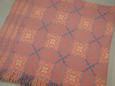 A DERW WELSH BLANKET in pink ground with typical geometric pale blue & near white patterning,