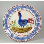 A LLANELLY POTTERY COCKEREL PLATE typically decorated with light-blue sponged rosette motifs to