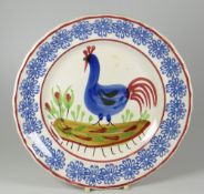 A LLANELLY POTTERY COCKEREL PLATE typically decorated with light-blue sponged rosette motifs to