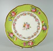 A NANTGARW PLATE with lobed border painted in lime-green with five floral sprays, decorated with