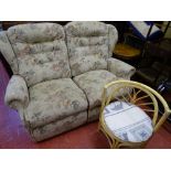 Light floral upholstered two seater couch and a single bamboo conservatory seat