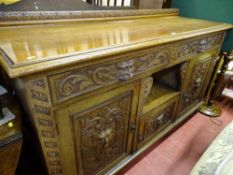 Oak railback sideboard with carved mask top drawers and base drawers and central single cupboard