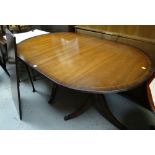 A reproduction mahogany & banded twin-pedestal extending dining table