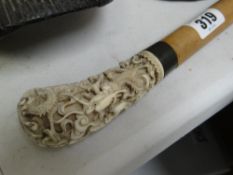 A carved ivory handled cane
