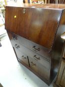A vintage mahogany narrow drop down bureau with a cupboard & drawer base