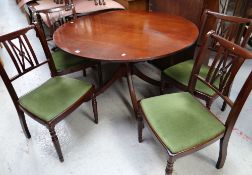 A good reproduction circular mahogany extending dining table together with four matching upholstered