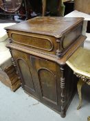 An antique oak opening top small desk with cupboard base
