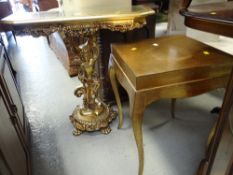 A gold painted cherub pedestal console table together with a similar gold painted side table