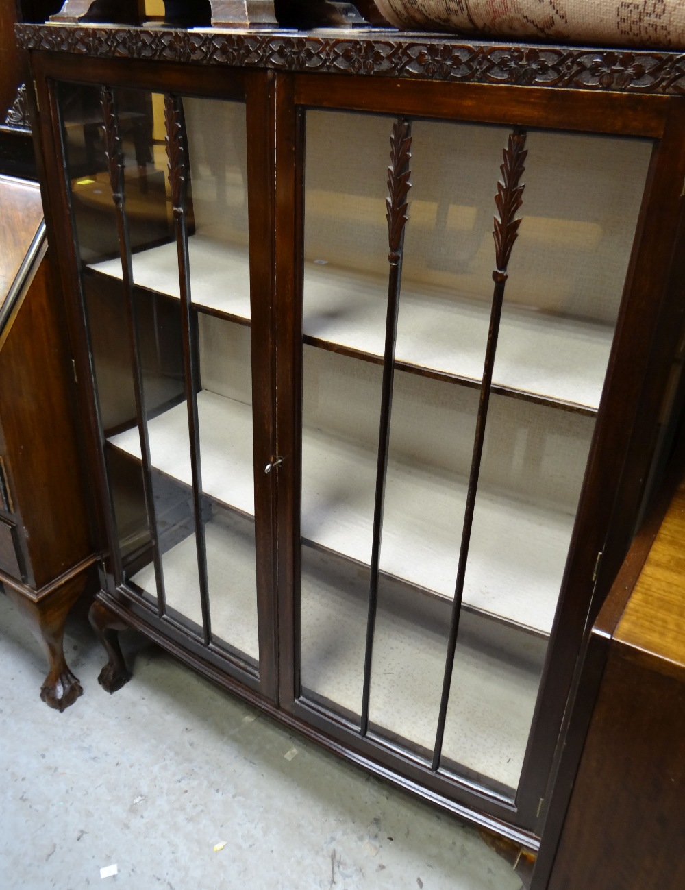 A vintage bow fronted display cabinet on raised ball & claw feet