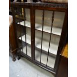 A vintage bow fronted display cabinet on raised ball & claw feet