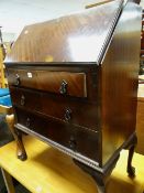 A vintage cross banded mahogany drop down three-drawer bureau on ball & claw feet