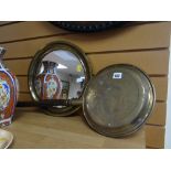 A circular brass framed wall mirror together with a brass bed warming pan