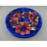 A MOORCROFT 'ANEMONE' 26.5 cms DIAMETER PLATE decorated on a cobalt ground, factory marks to the