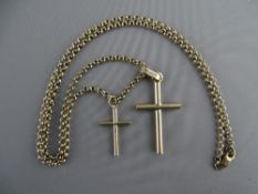 A NINE CARAT GOLD NECK CHAIN with two rounded form crucifixes of graduated size, 12.8 grms
