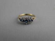 A NINE CARAT GOLD SAPPHIRE & DIAMOND DRESS RING having a centre sapphire with two flanking tiny