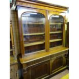 A VICTORIAN MAHOGANY TWO DOOR BOOKCASE CUPBOARD, the twin doors of the upper section having gently