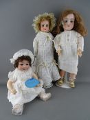 THREE ANTIQUE GERMAN BISQUE HEADED DOLLS including a cloth bodied Armand Marseille no. 3700,
