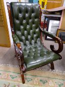 A MODERN GREEN LEATHER EFFECT 'X' FRAME ARMCHAIR with button back upholstery, 95 cms high, 60 cms