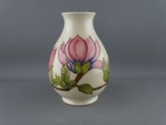 A MOORCROFT 'MAGNOLIA' 19 cms HIGH BULBOUS VASE decorated on a cream ground, factory stamps to the