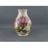 A MOORCROFT 'MAGNOLIA' 19 cms HIGH BULBOUS VASE decorated on a cream ground, factory stamps to the