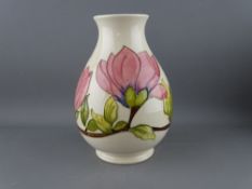 A MOORCROFT 'MAGNOLIA' 19 cms HIGH BULBOUS VASE decorated on a cream ground, factory stamps to the