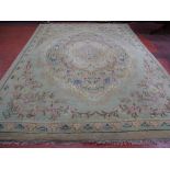 A VINTAGE TUFTED WOOLLEN CARPET having a central floral cartouche and spandrel corners with a single