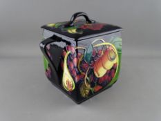 A MOORCROFT 'QUEEN'S CHOICE' BISCUIT BOX & COVER decorated on a black ground, designed by Emma