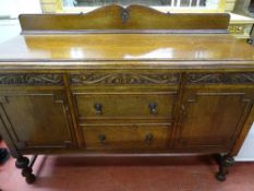 A VINTAGE OAK RAILBACK SIDEBOARD with carved detail on bulbous front supports, 115.5 cms high