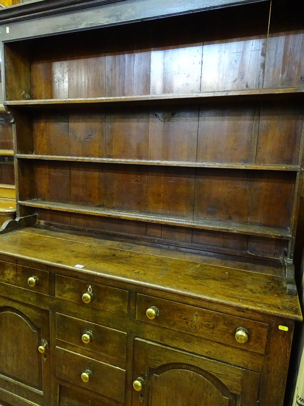 AN EARLY 19th CENTURY CAERNARFONSHIRE OAK DRESSER having a three shelf rack over a base having