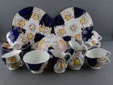 TWENTY NINE PIECES OF GAUDY WELSH 'TULIP' TEAWARE to include a muffin dish and cover, two sandwich