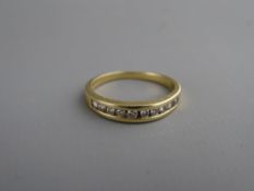 A FOURTEEN CARAT GOLD HALF ETERNITY RING, channel set with ten diamonds, size 'Q', 2.5 grms gross