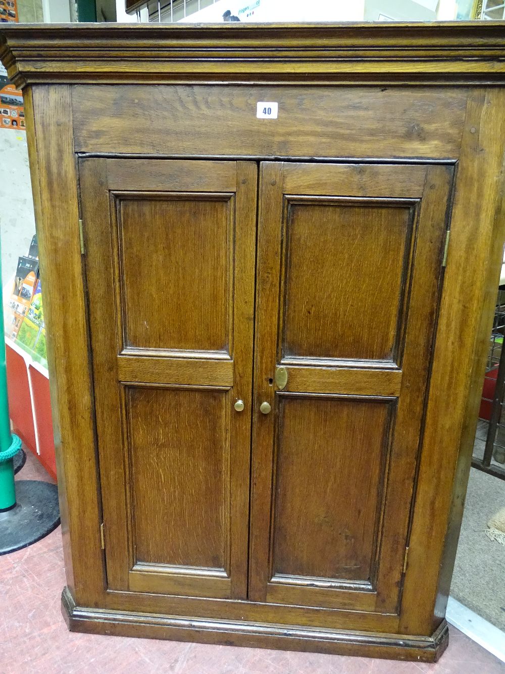 AN OAK TWO DOOR PANEL FRONT WALL HANGING CORNER CUPBOARD with shaped interior shelves, 111 cms high,